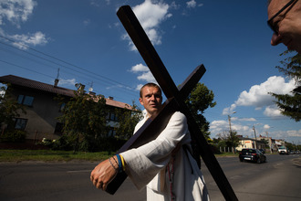 27-letni pielgrzym Michał zakreśla na mapie Polski znak krzyża.